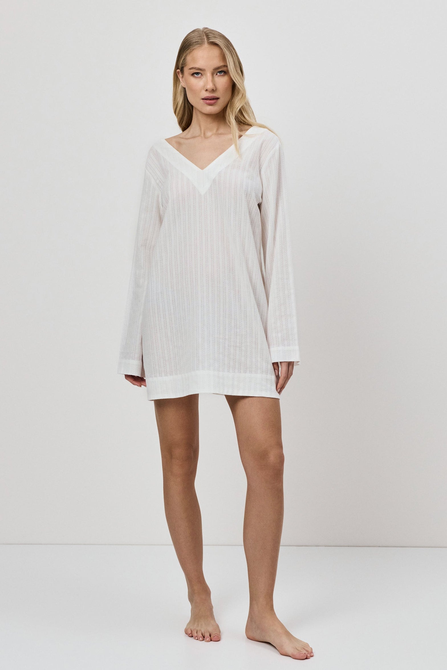 Woman wearing a white dress against a plain background