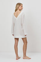 Woman wearing a white dress against a plain background