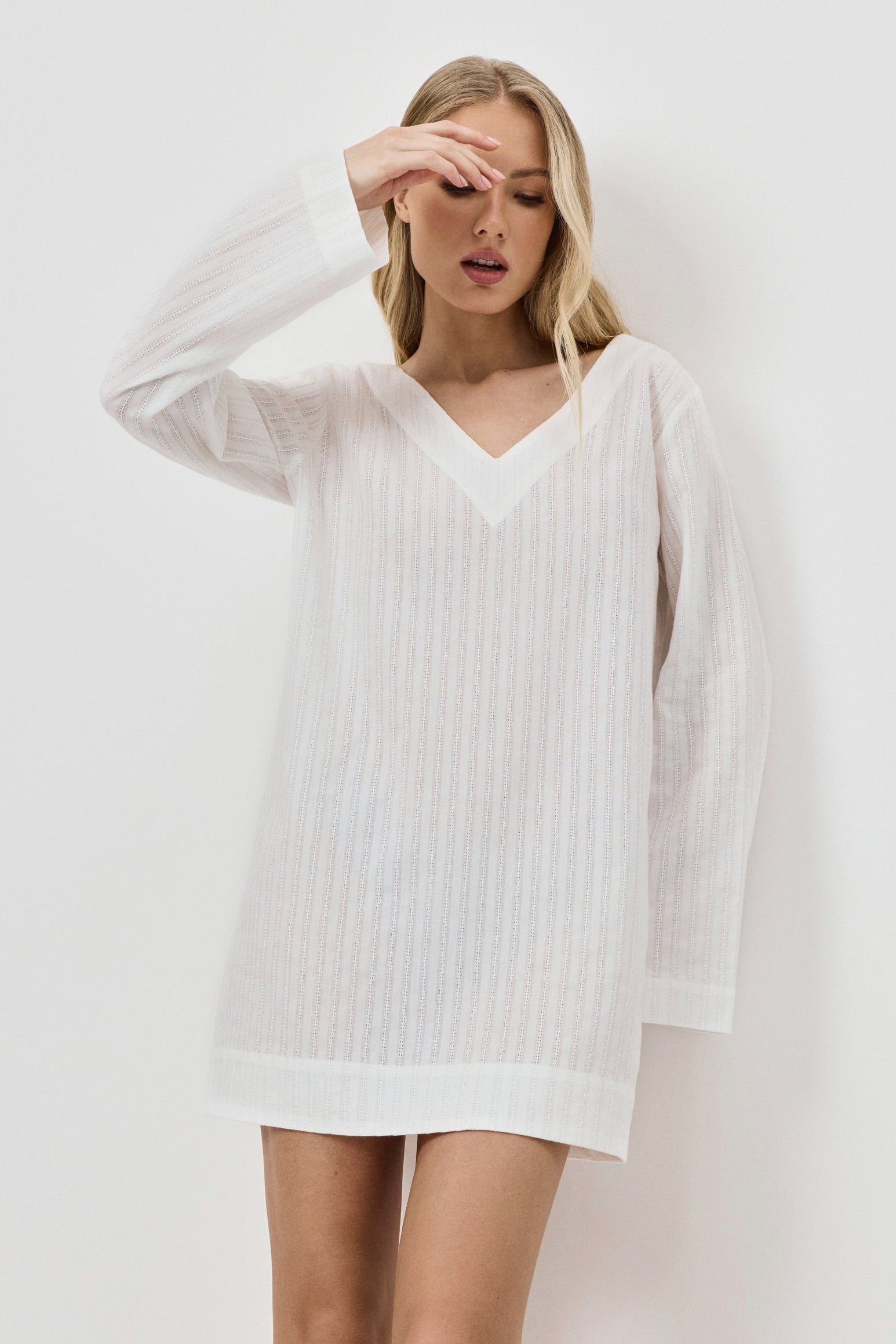 Woman wearing a white dress against a plain background