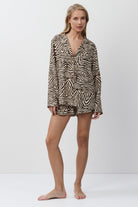 Woman wearing a zebra print shirt and shorts on a white background
