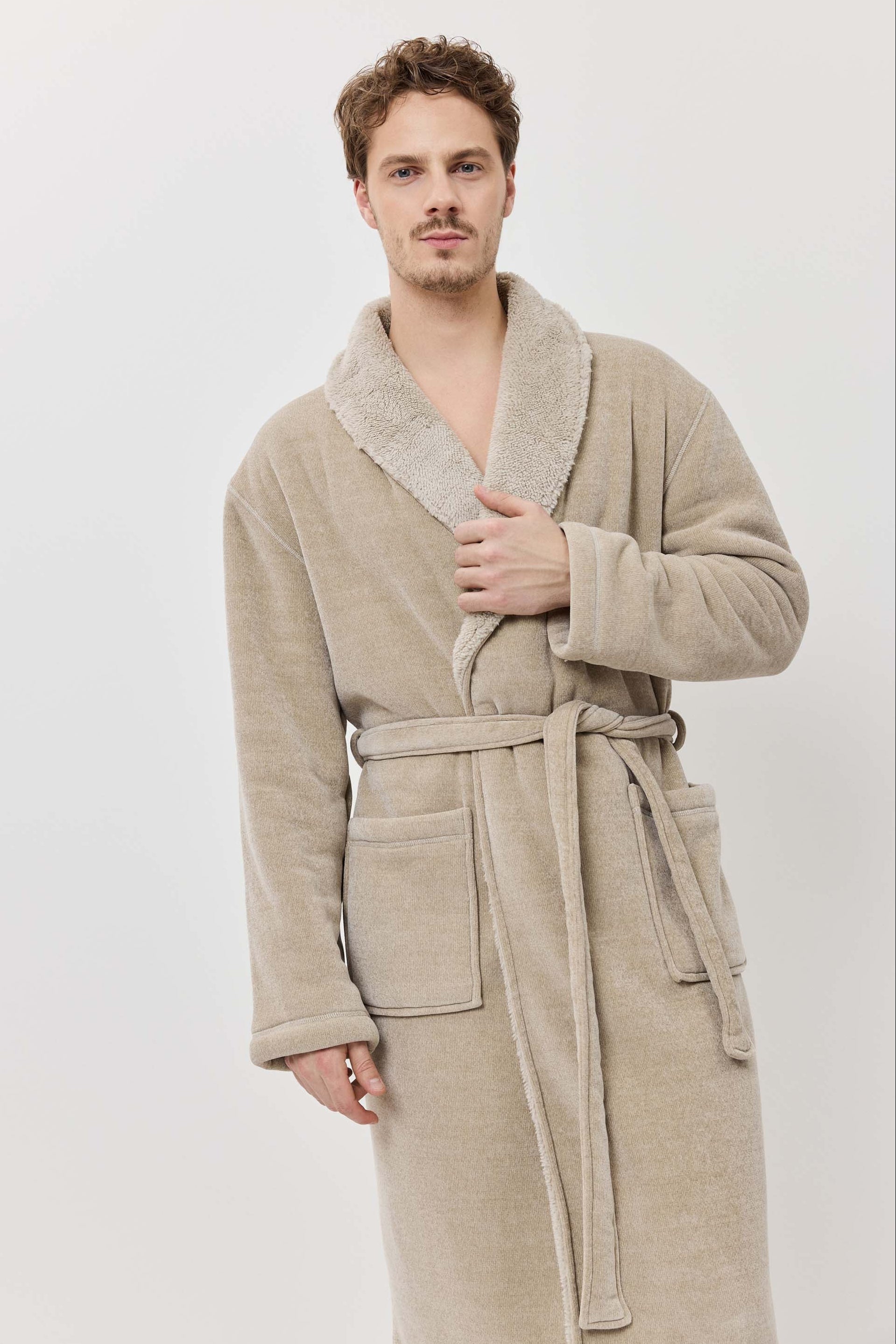 Man wearing a beige robe against a white background