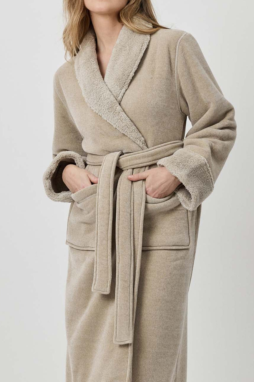 Woman wearing a beige robe against a white background