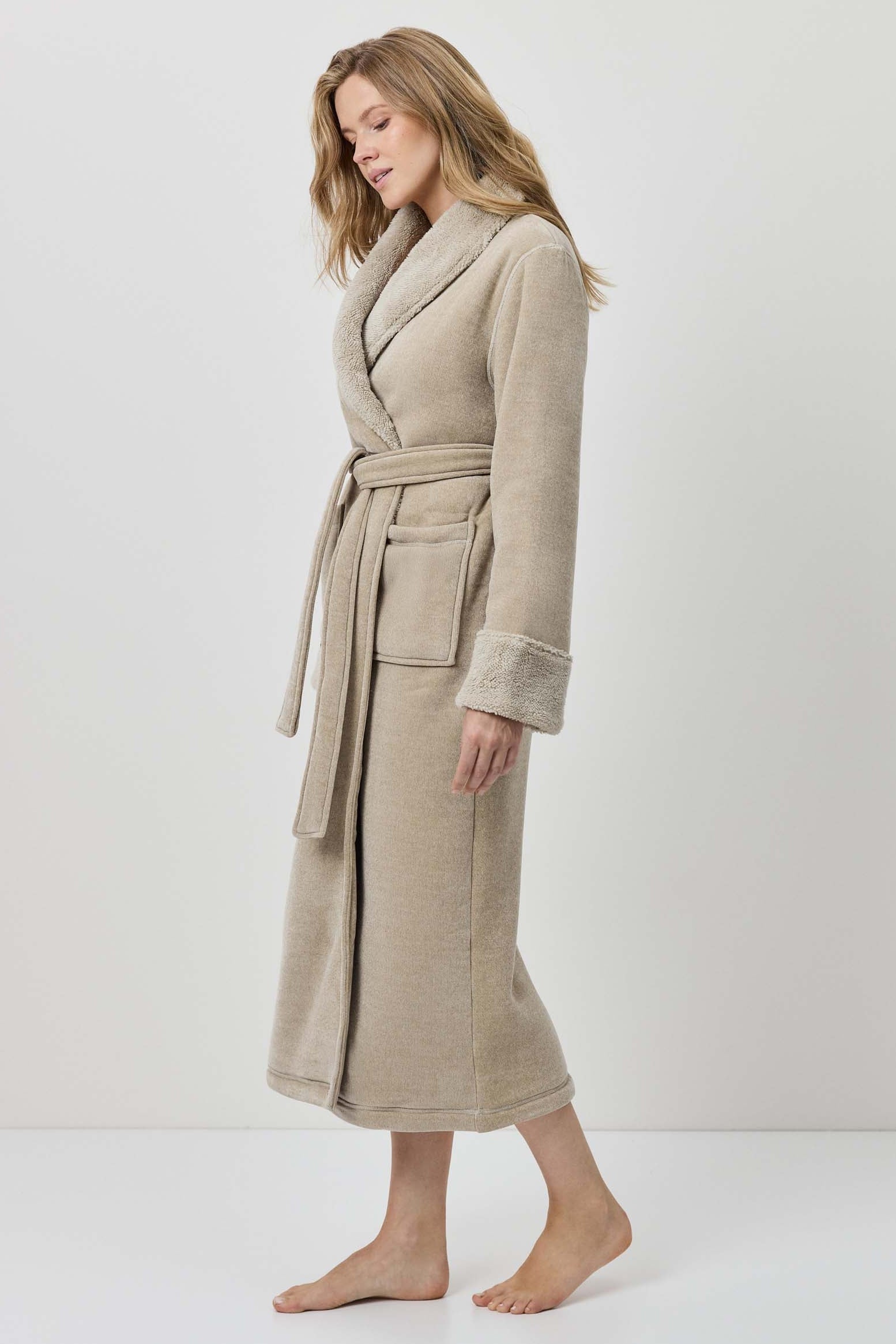 Woman wearing a beige robe against a white background