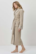 Woman wearing a beige robe against a white background