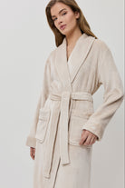 Woman wearing a beige bathrobe on a white background