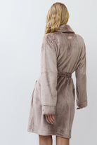 Woman wearing a choco bathrobe against a white background