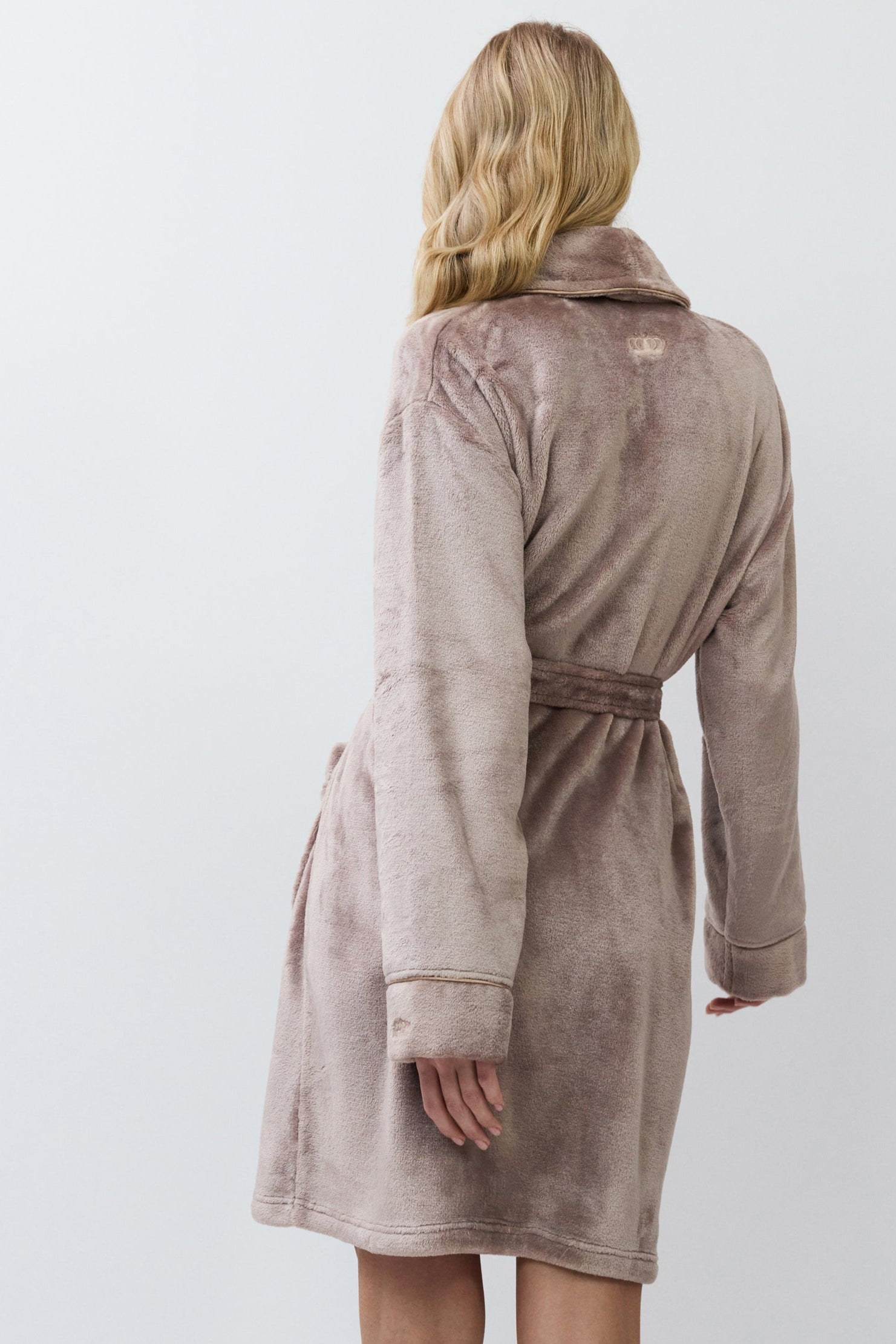 Woman wearing a choco bathrobe against a white background