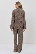Person wearing a brown patterned suit on a white background