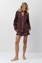 Woman wearing a patterned pajama set on a white background
