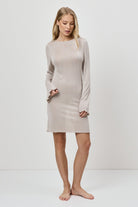 Woman wearing a beige dress against a white background