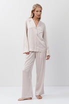 Woman wearing a pink pajama set on a white background