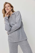 Woman wearing a gray ribbed loungewear set on a white background