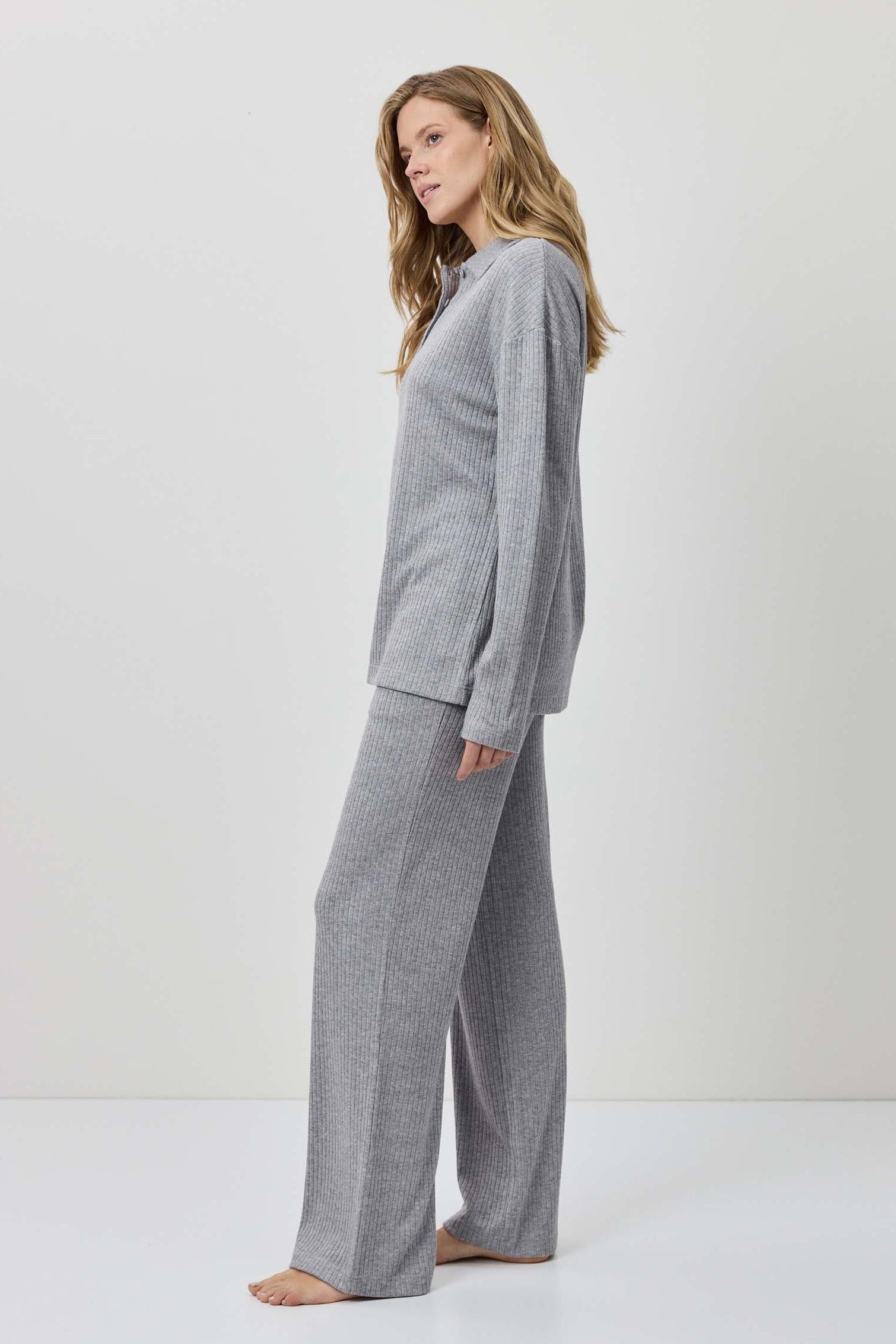 Woman wearing a gray outfit against a white background