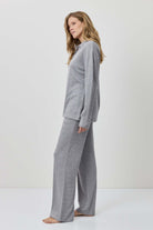 Woman wearing a gray outfit against a white background