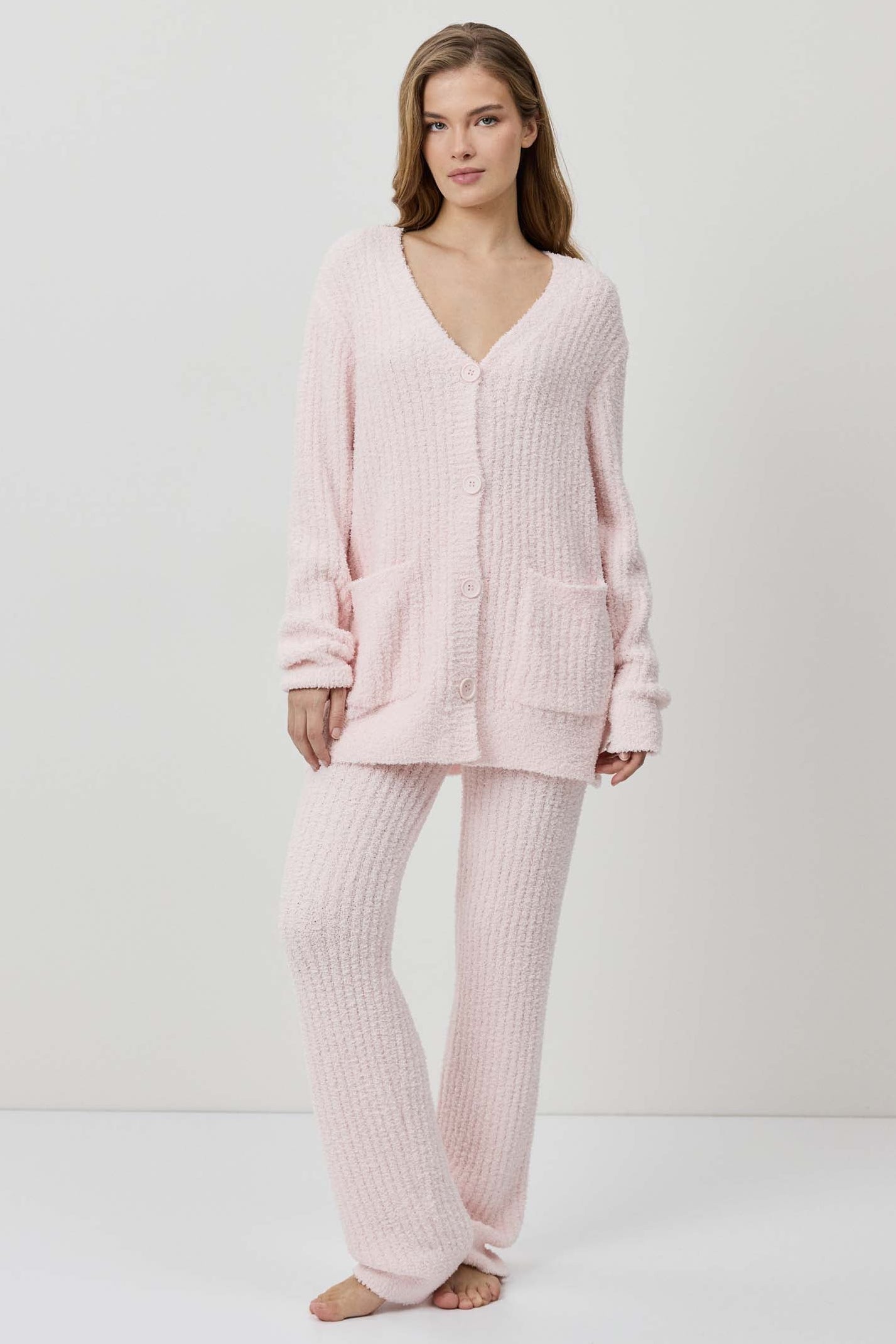 A woman wearing a light pink ribbed knit lounge set.