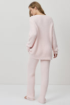 A woman wearing a light pink ribbed knit lounge set.