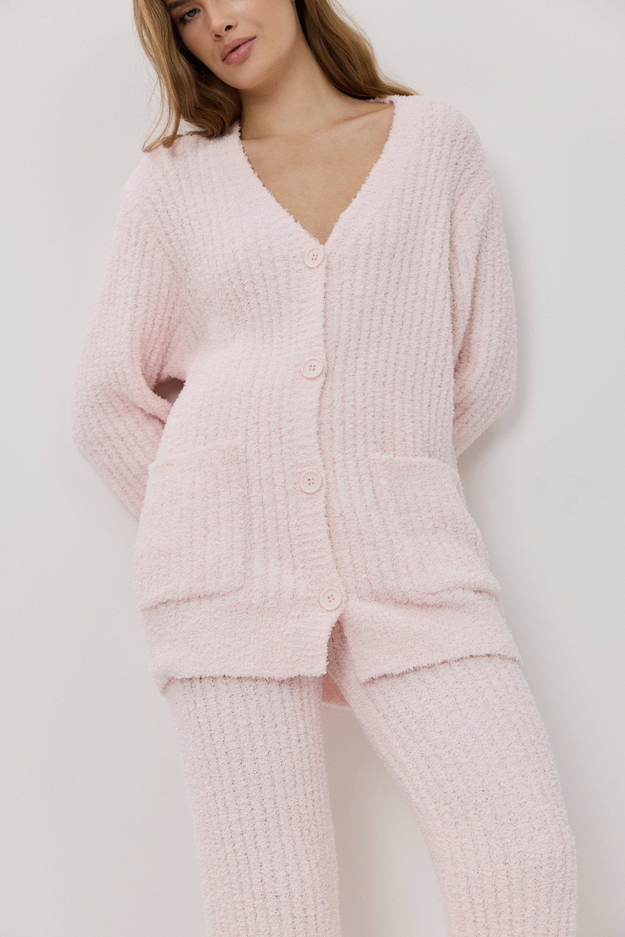 A woman wearing a light pink ribbed knit lounge set.