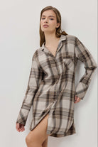 Woman wearing a plaid shirt dress against a plain background