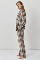 Woman wearing a plaid pajama set against a white background