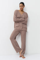 Woman wearing a brown ribbed knit set against a white background