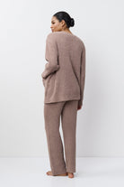 Woman wearing a brown ribbed knit outfit on a white background