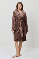 Woman wearing a brown plush robe on a white background