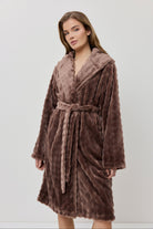 Woman wearing a brown plush robe against a white background