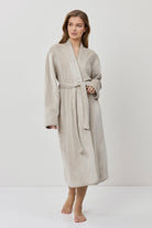 Woman wearing a beige robe on a white background