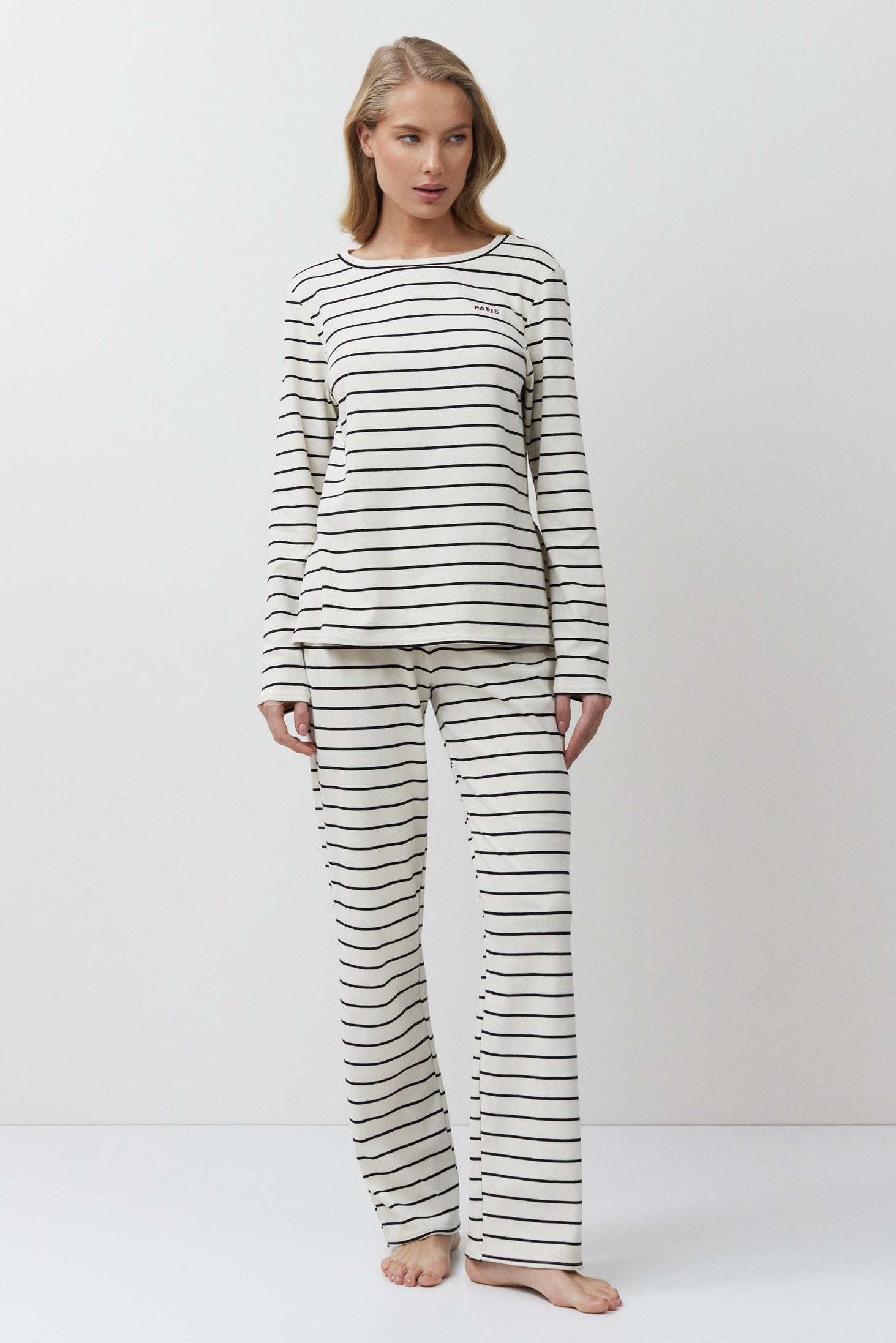 Woman wearing a striped pajama set against a white background