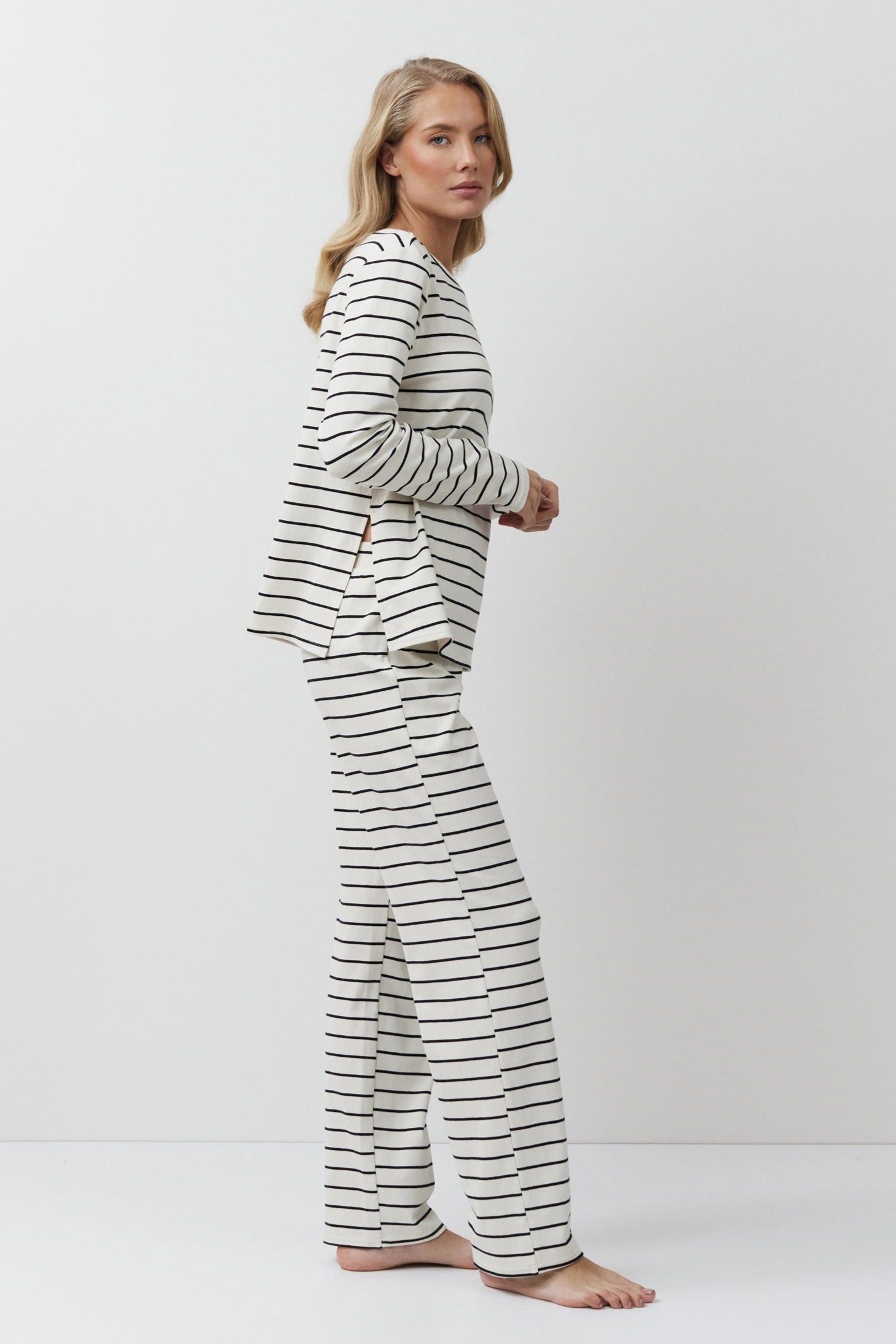 Woman wearing a striped pajama set on a white background