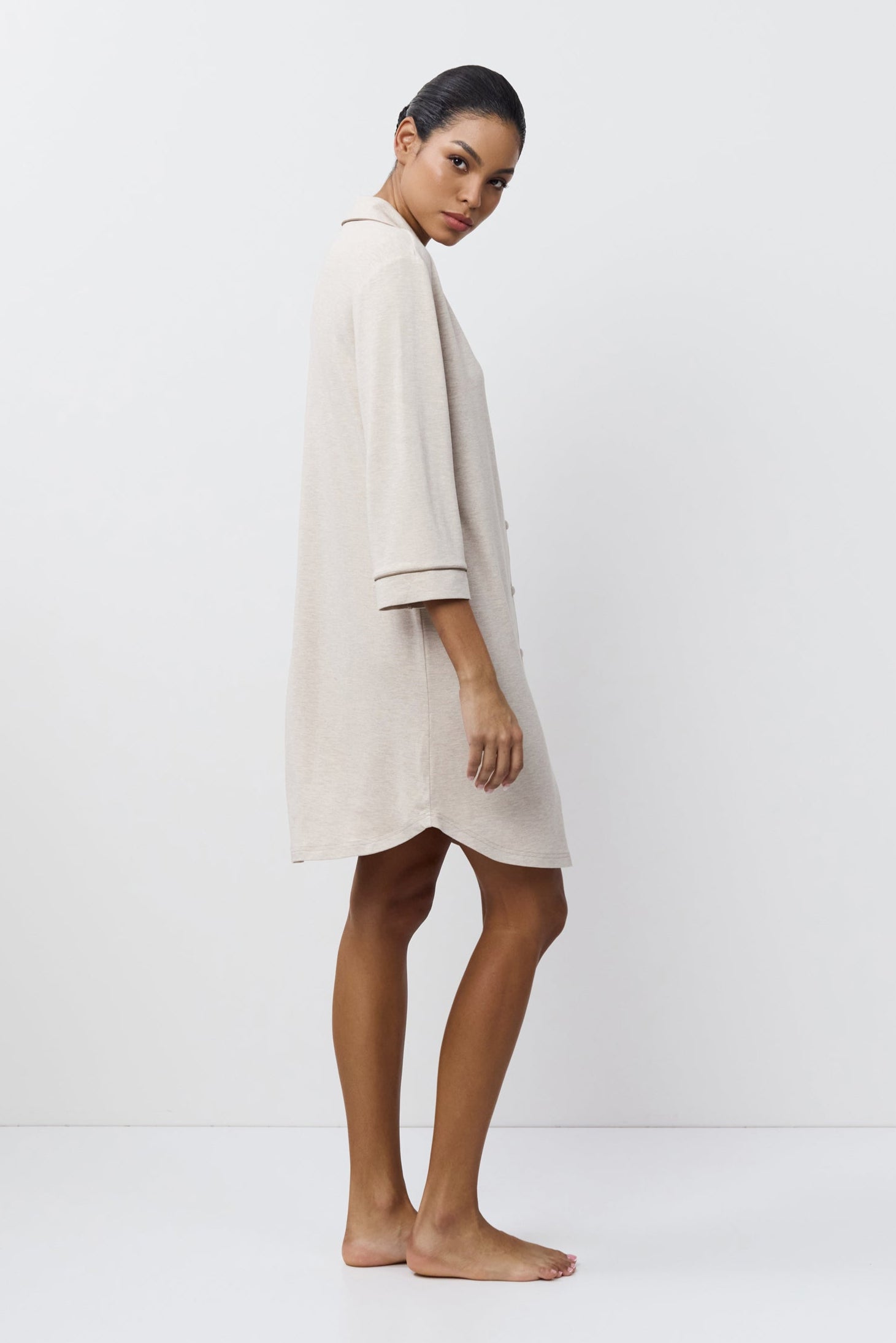 Woman wearing a beige nightdress against a white background
