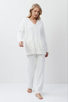 Woman wearing a white loungewear set on a plain background