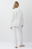 Person wearing a white loungewear set standing against a plain white background