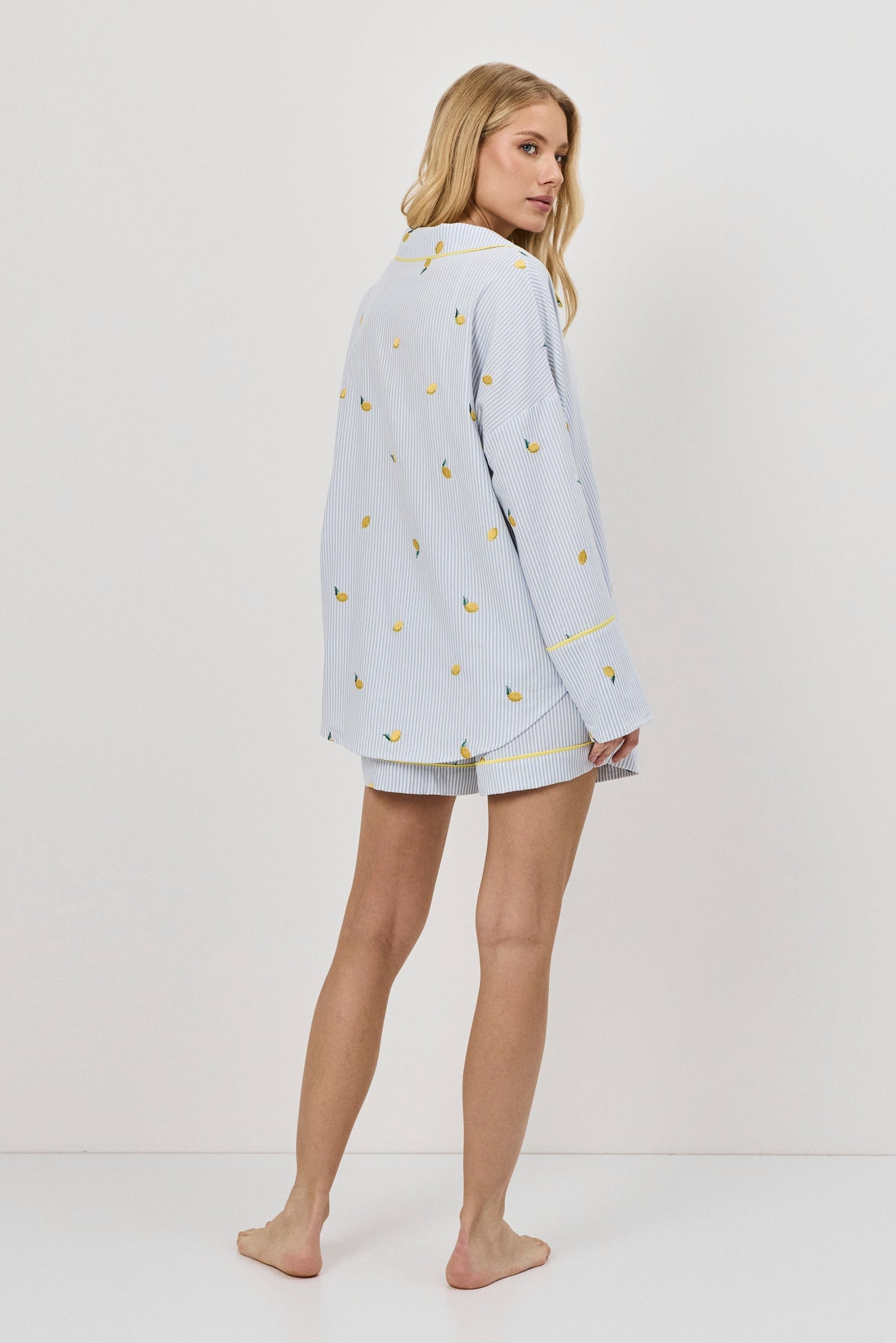 Woman wearing a light blue pajama set with a white background