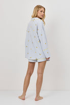 Woman wearing a light blue pajama set with a white background