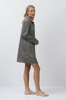 Woman wearing a patterned nightdress against a white background