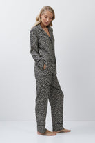 Woman wearing a leopard patterned pajama set on a white background
