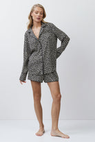 Woman wearing a leopard patterned pajama set on a white background