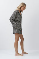 Woman wearing a leopard patterned outfit on a white background