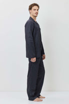 Man wearing a black polka dot pajama set on a white background
