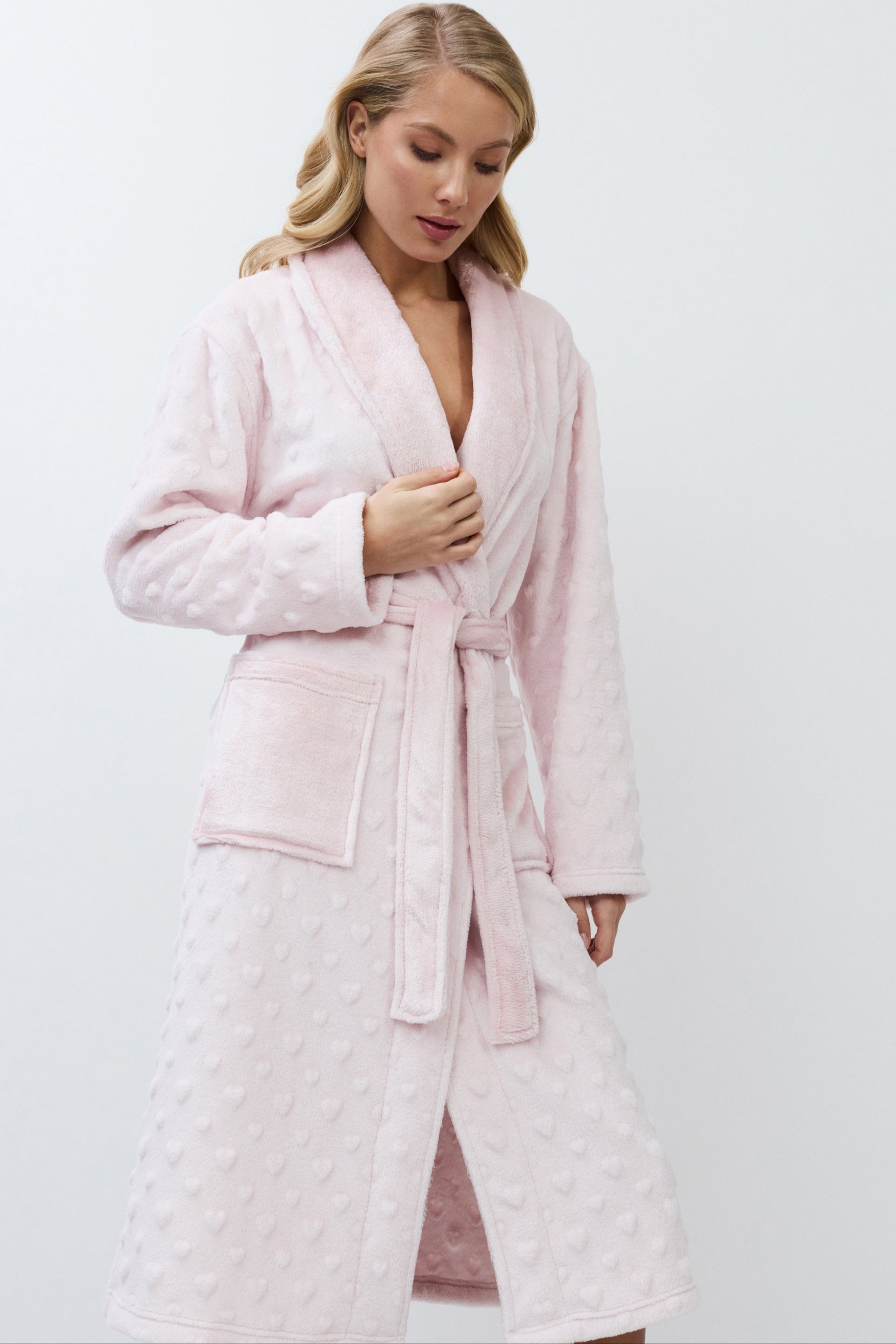 Woman wearing a pink athrobe against a white background
