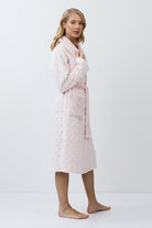 Woman wearing a pink quilted bathrobe on a white background
