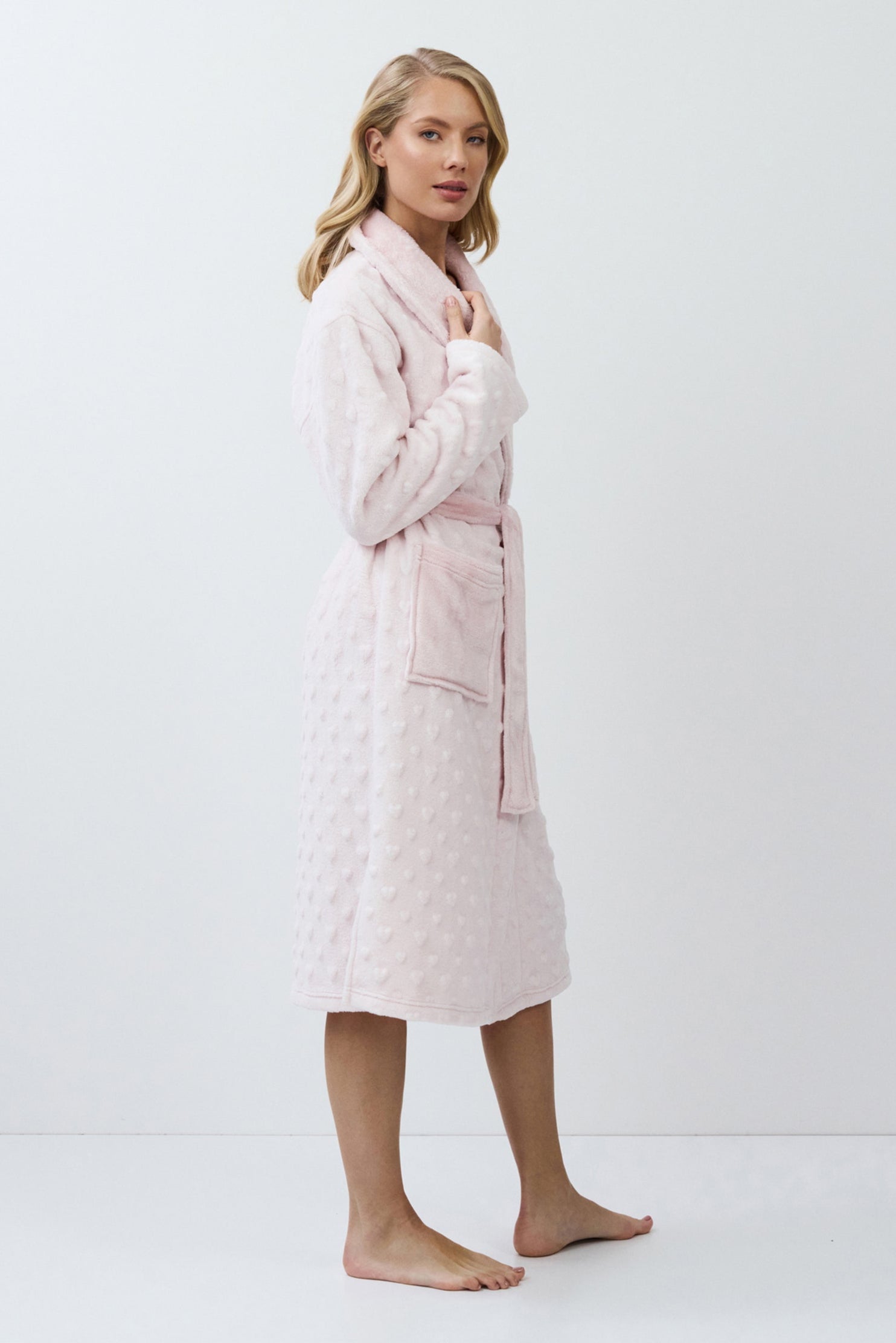 Woman wearing a pink quilted bathrobe on a white background