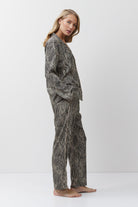 Woman wearing a patterned pajama set on a white background