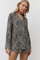 Woman wearing a patterned shirt against a white background