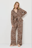 Woman wearing leopard print pajamas against a white background
