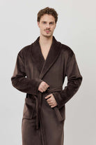 Man wearing a brown robe against a white background