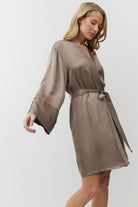 Woman wearing a choco gown with long sleeves on a white background