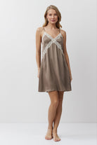Woman wearing a brown nightdress with lace details on a white background