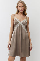Woman wearing a beige nightdress with lace details on a white background